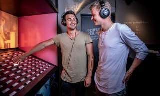 zwei junge Männer hören Musik an einer Jukebox